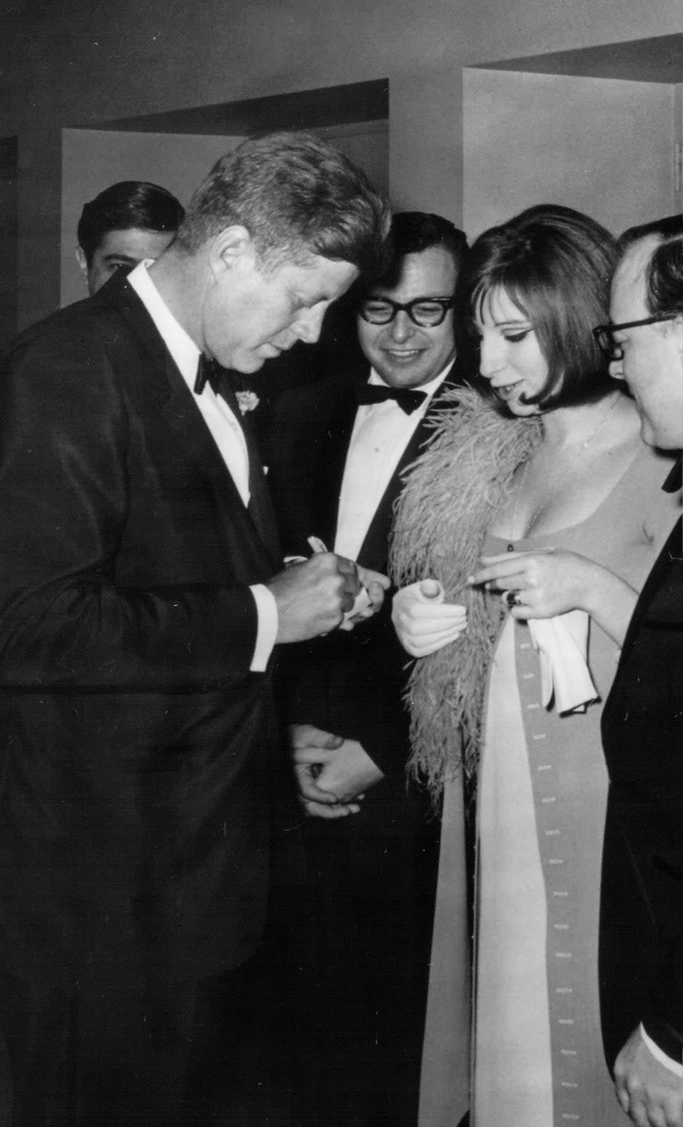  President John F. Kennedy signs an autograph for Barbra Streisand at an event May 24, 1963