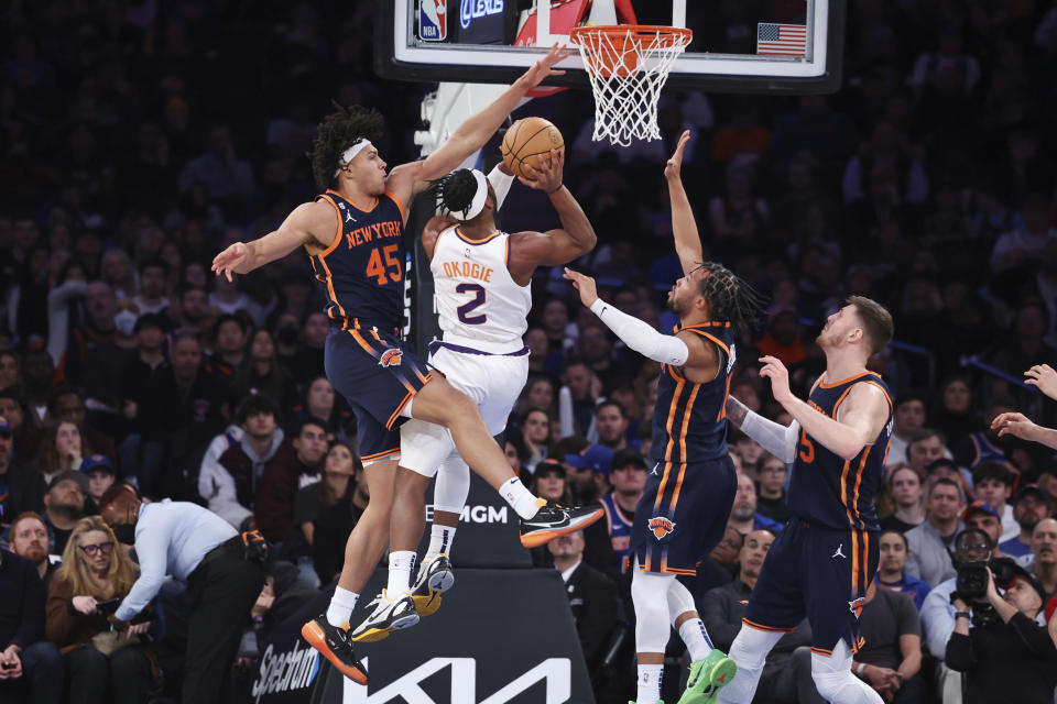 Phoenix Suns forward Josh Okogie (2) drives to the basket against New York Knicks center Jericho Sims (45), guard Jalen Brunson, second from right, and center Isaiah Hartenstein, right, during the first half of an NBA basketball game, Monday, Jan. 2, 2023, in New York. (AP Photo/Jessie Alcheh)