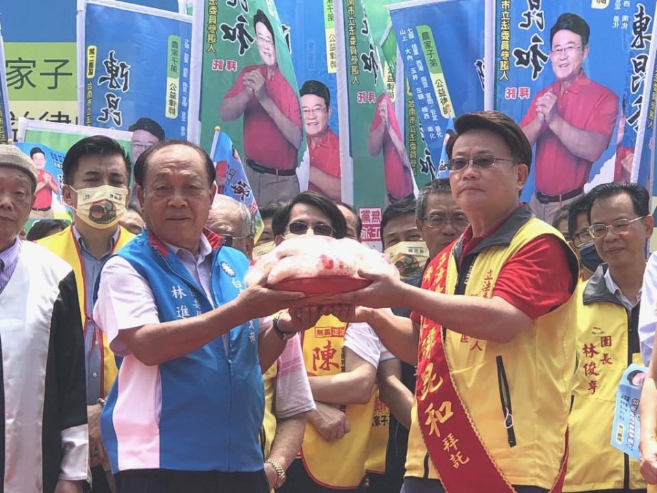 國民黨台南市黨部主委林進旺(左)送上包子，祝賀陳昆和高票當選。(記者盧萍珊攝)