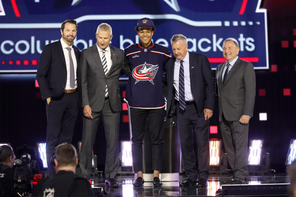 Cayden Lindstrom, center, poses after being selected by the Columbus Blue Jackets during the first round of the NHL hockey draft Friday, June 28, 2024, in Las Vegas. (AP Photo/Steve Marcus)