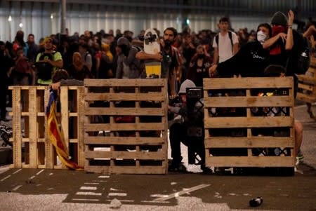 Protesters build a barricade during a demonstration at the airport, after a verdict in a trial over a banned independence referendum, in Barcelona