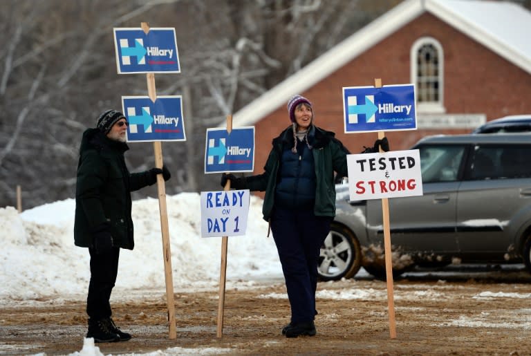 Supporters of US Democratic presidential candidate Hillary Clinton display campaign posters outside the town hall as local residents vote for the first US presidential primary in Canterbury, New Hampshire, on February 9, 2016