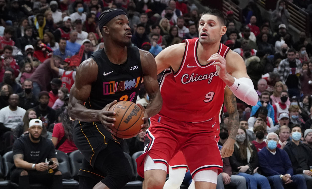 Miami Heat forward Jimmy Butler is defended by Chicago Bulls center Nikola Vucevic.