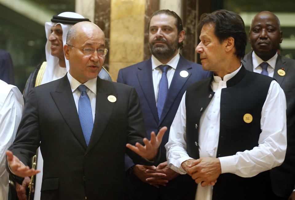 Pakistan's Prime Minister Imran Khan, right, listens to Iraq's President Barham Salih during a group picture ahead of Islamic Summit of the Organization of Islamic Cooperation (OIC) in Mecca, Saudi Arabia, early Saturday, June 1, 2019. Muslim leaders from some 57 nations gathered in Islam's holiest city of Mecca late Friday to discuss a breadth of critical issues ranging from a spike in tensions in the Persian Gulf, to Palestinian statehood, the plight of Rohingya refugees and the growing threat of Islamophobia. (AP Photo/Amr Nabil)