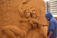 <p>A sand carver works on a sculpture during the Sand Sculpture Festival “Disney Sand Magic” in Ostend, Belgium. (Photo courtesy of Disneyland Paris) </p>