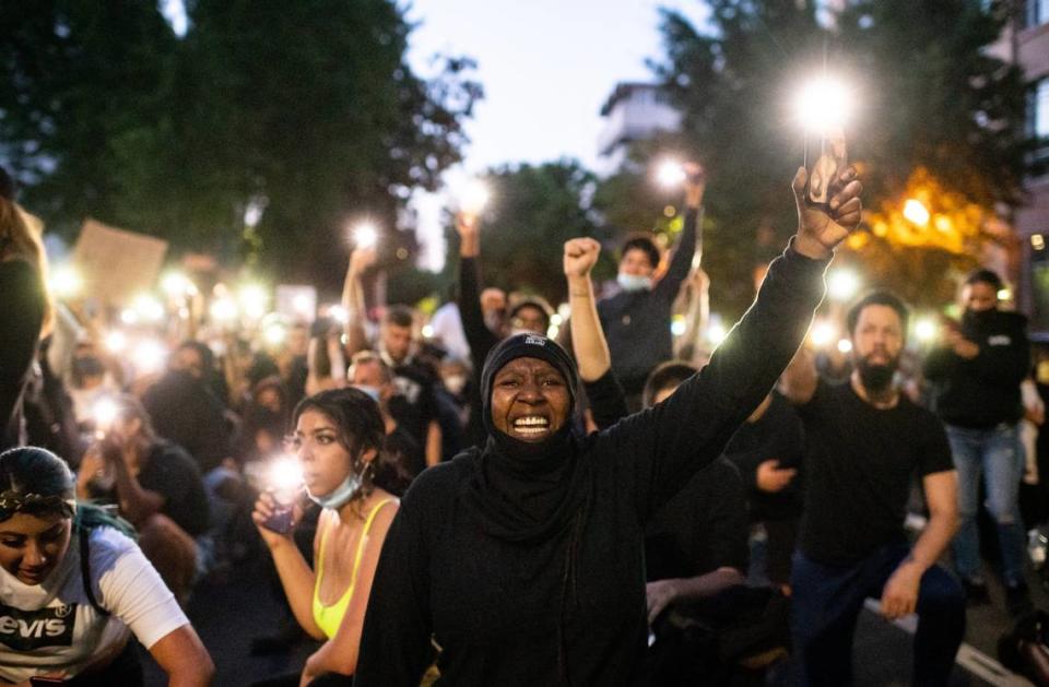 Musaqoi Young, of Sacramento, and others hold up their cell phones to honor Stephon Clark during a rally with his brother Stevante Clark in front of City Hall on Monday, June 1, 2020, in Sacramento after days of heated demonstrations to protest the death of George Floyd, who was killed by police in Minneapolis on Memorial Day. Young, who said sheís been with Black Lives Matter for four days, said people need to unite to fight against corrupt police in Sacramento ìbecause theyíre killing us like we donít matter, they treat us like weíre cattle,î she said, ìwe need to stop this.î The California National Guard was called in and citywide curfew implemented, while the looting by divergent groups and use of force from police that marked earlier days was largely absent.