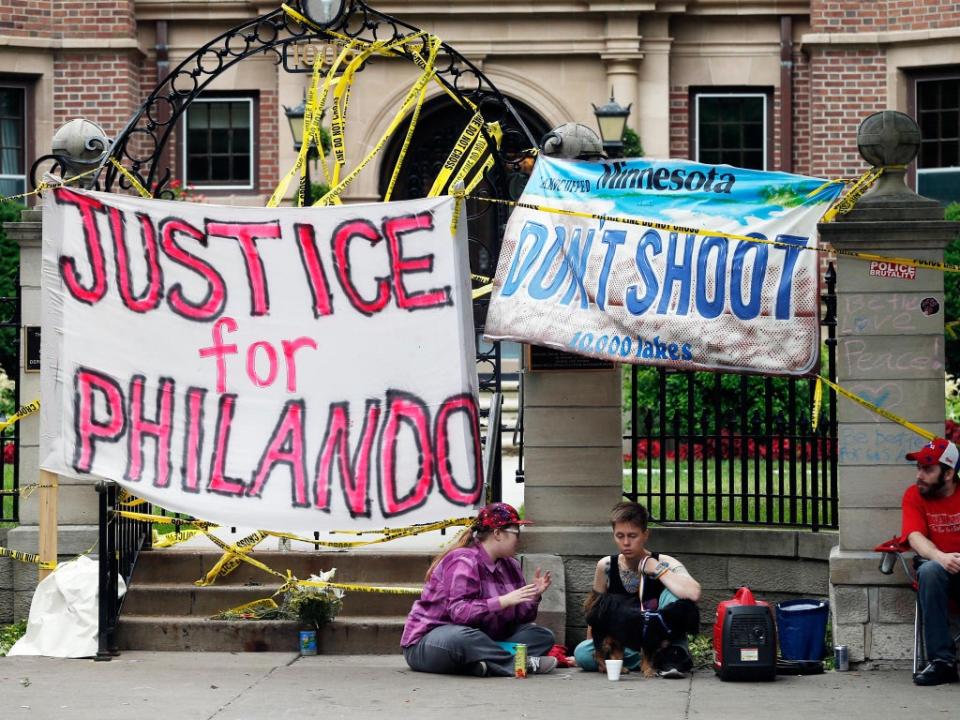 Protesters hang banners outside of the governor's residence in St Paul, Minnesota, after the police killing of Philando Castile, a Black man, in 2016 (Associated Press)