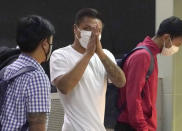 Pyae Lyan Aung, center, a substitute goalkeeper of the Myanmar national team who raised a three-finger salute during a qualifying match for the 2022 World Cup in late May, arrives at Kansai International Airport in Osaka Prefecture, Japan on Wednesday June 16, 2021. Pyae Lyan Aung has refused to return home and is seeking asylum, a request the government was considering taking into account unrest in his country following a coup.(Kyodo News via AP)