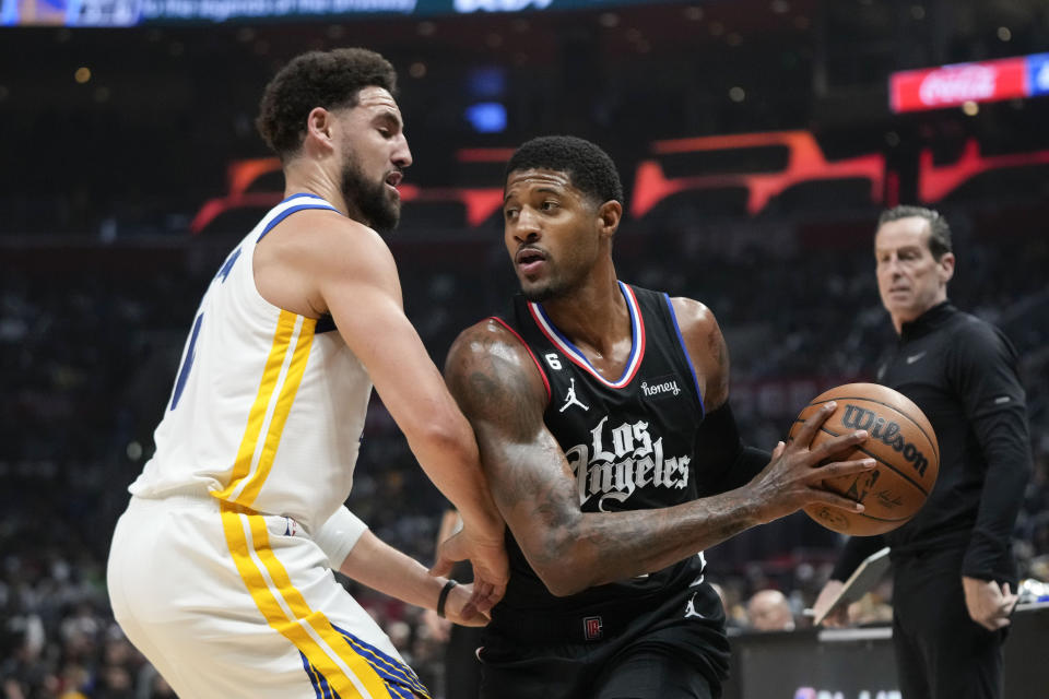 Golden State Warriors' Klay Thompson, left, pressures Los Angeles Clippers' Paul George during first half of an NBA basketball game Wednesday, March 15, 2023, in Los Angeles. (AP Photo/Jae C. Hong)