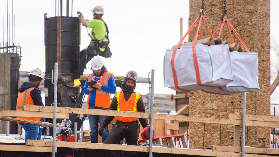 A construction worker watches a load get lifted while working on building the Ferguson International Center on the Indiana University campus on Thursday, Dec. 2, 2021.