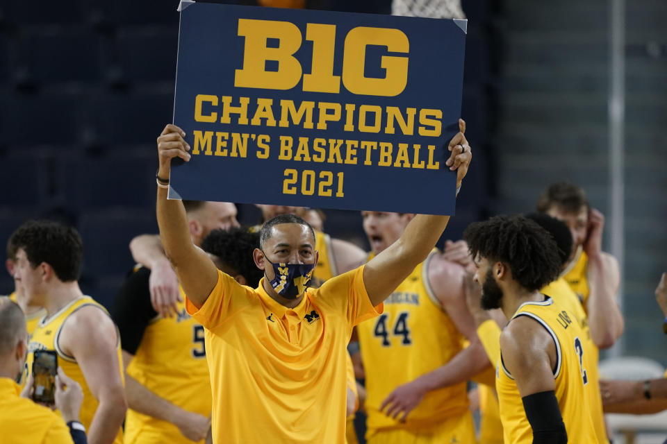 FILE - Michigan coach Juwan Howard holds a championship sign after the team's win over Michigan State in an NCAA college basketball game in Ann Arbor, Mich., in this Thursday, March 4, 2021, file photo. Michigan’s Juwan Howard is coach of the year in the Big Ten, announced Tuesday, March 9, 2021. (AP Photo/Carlos Osorio, File)