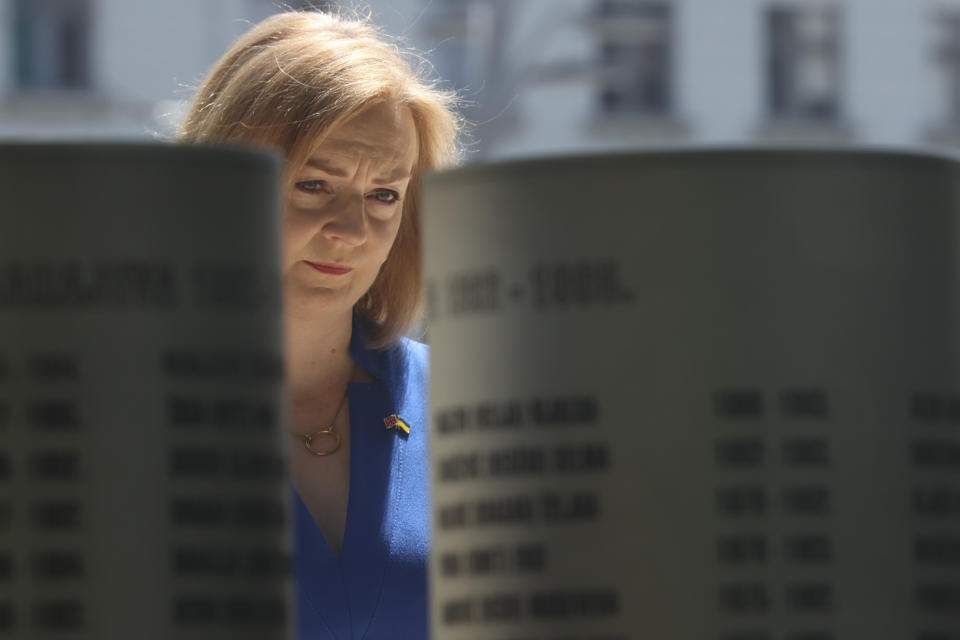 Elizabeth Truss, Britain's Secretary of State for Foreign, Commonwealth and Development Affairs, looks at pillars bearing names of victims at a monument dedicated to the children killed during the Bosnian war in the besieged Bosnian capital in Sarajevo, Bosnia, Thursday, May 26, 2022. (AP Photo/Armin Durgut)