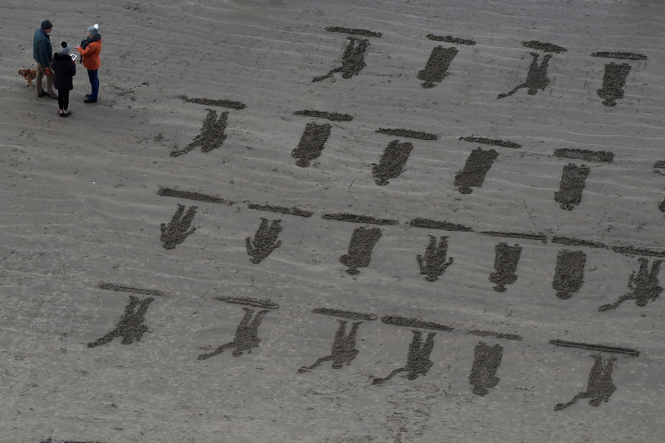 <p>Pictures of soldiers are etched in the sand on Armistice day on Downhill Beach in Coleraine, Northern Ireland. (REUTERS/Clodagh Kilcoyne) </p>