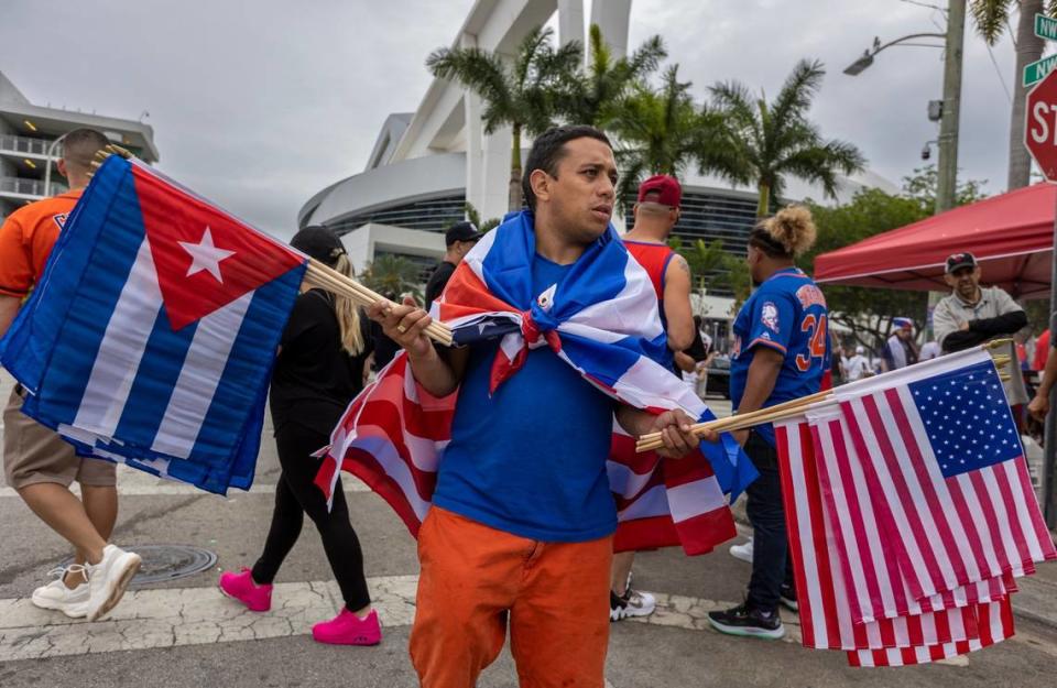 MIAMI, FL- March 19, 2023 - A vendor sells American and Cuban flags in front of loanDepot Park prior to the start of the baseball game between Cuba and the United States.