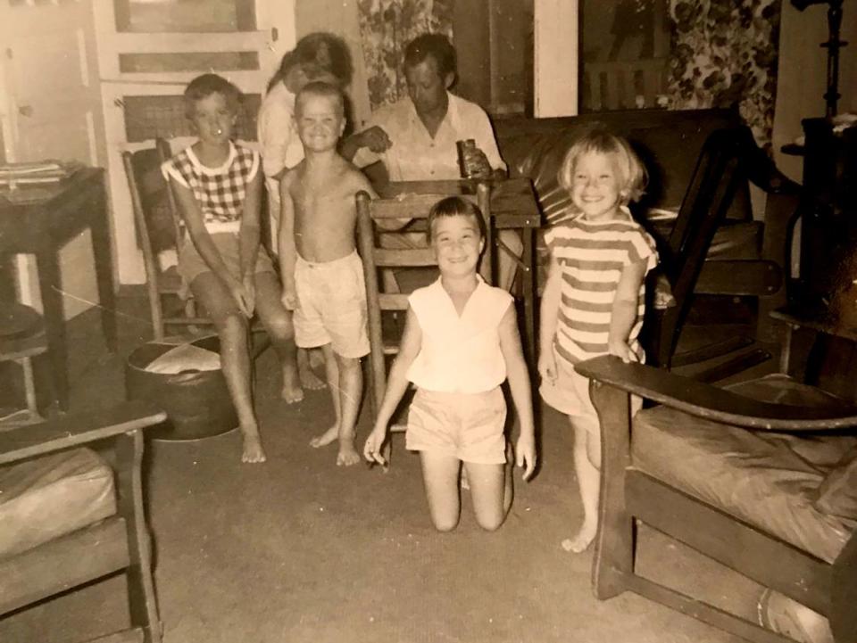 Beth Burns and her cousins gather around a card table during a family vacation in the 1950s. Burns is in the striped shirt on the right side of the photo, next to her father. 