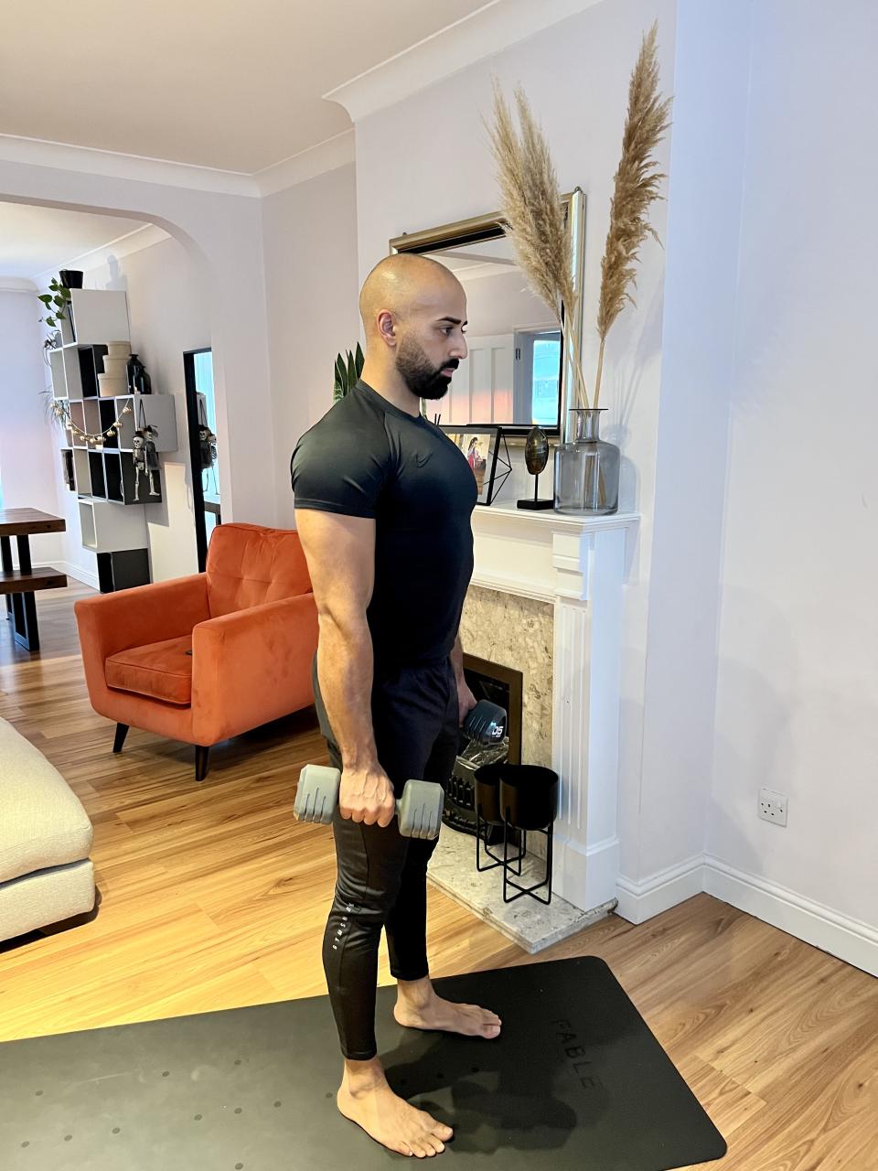 Personal trainer Ali Malik demonstrating the dumbbell hammer curl