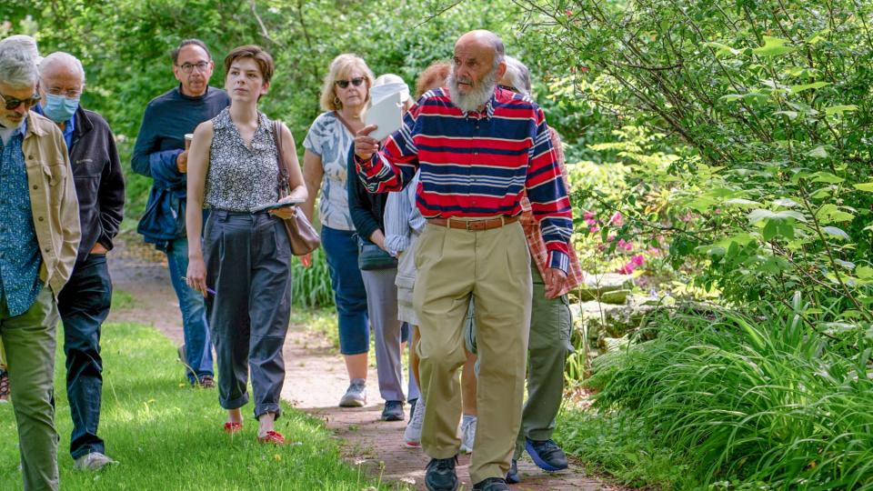 Amy Russo, center left, and others listen as former Rhode Island Supreme Court Justice Gilbert Indeglia gives commentary during a recent tour of Kingston Village.