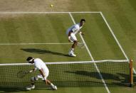 Serbia's Novak Djokovic (top) in action with Argentina's Juan Martin Del Potro after his win during day eleven of the Wimbledon Championships at The All England Lawn Tennis and Croquet Club, Wimbledon.