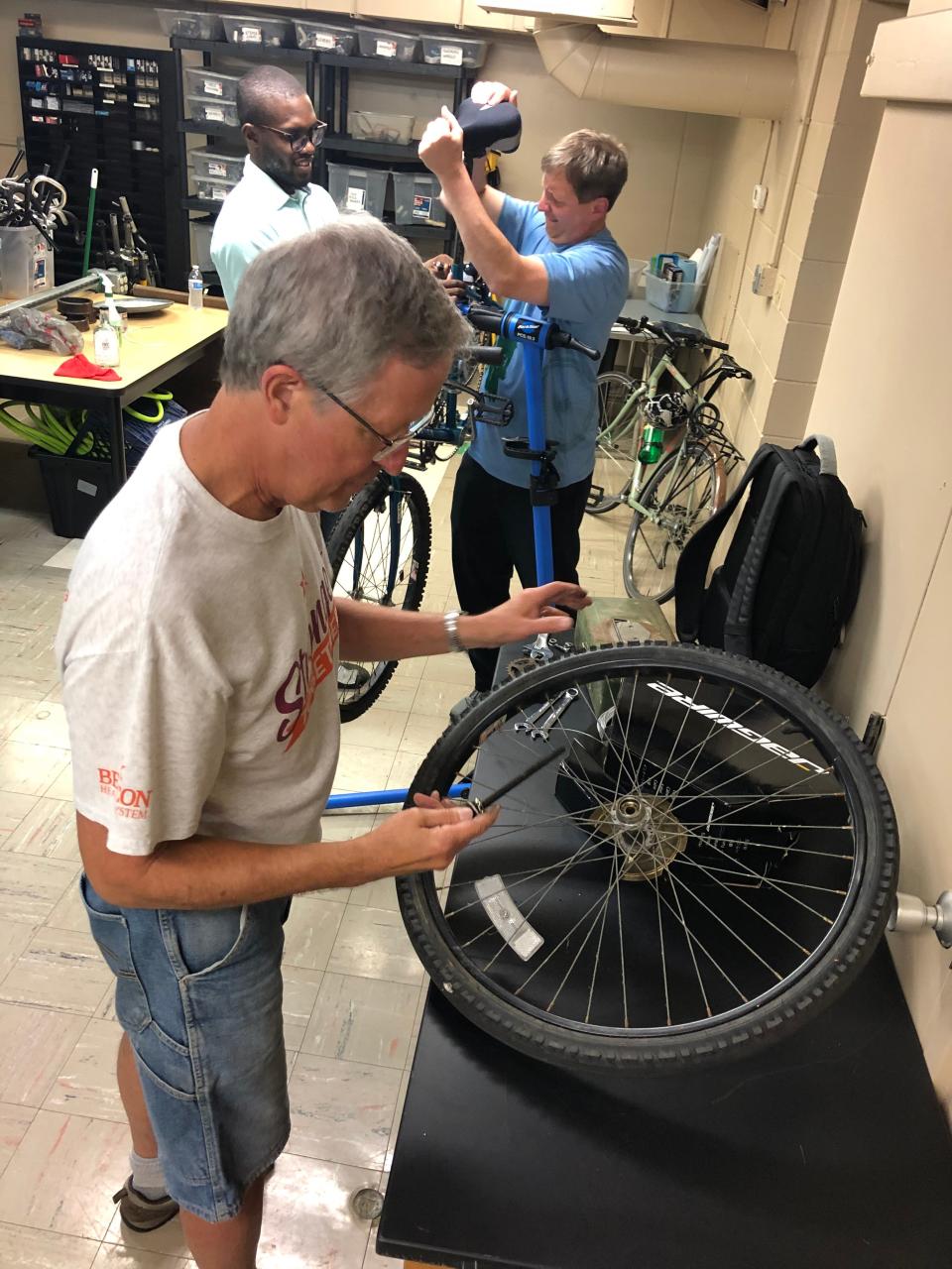 Volunteer Loren Waggy fixes a wheel downstairs at the new home of the South Bend Bike Garage on July 13, 2022.
