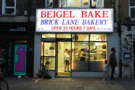  People stand by a social distancing information flyer on the glass window of the Beigel Bake bakery. The Government has made it mandatory to wear face coverings in all public transport, supermarkets and indoor shopping centers as a measure to combat the spread of the novel coronavirus. (Photo by David Mbiyu / SOPA Images/Sipa USA) 