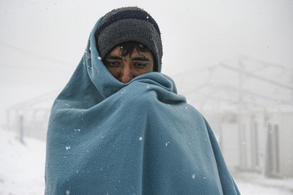 A migrant walks during snowfall at the Lipa camp, outside Bihac, Bosnia, Friday, Jan. 8, 2021. A fresh spate of snowy and very cold winter weather on has brought more misery for hundreds of migrants who have been stuck for days in a burnt out camp in northwest Bosnia waiting for heating and other facilities. (AP Photo/Kemal Softic)