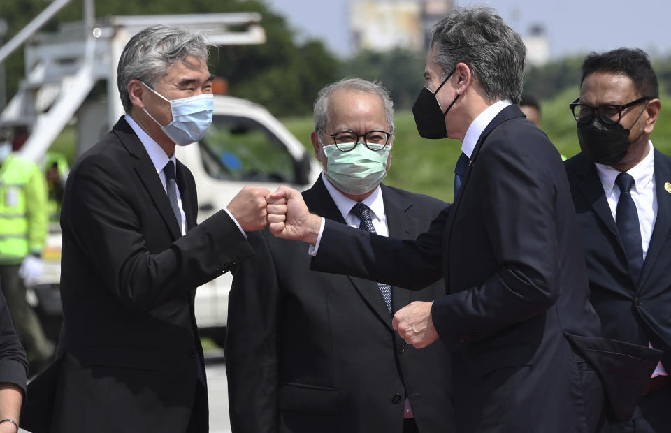 U.S. Secretary of State Antony Blinken, second right, is greeted by U.S. Ambassador Sung Kim, left, as he arrives at the international airport in Jakarta, Monday, Dec. 13, 2021. (Olivier Douliery/Pool Photo via AP)