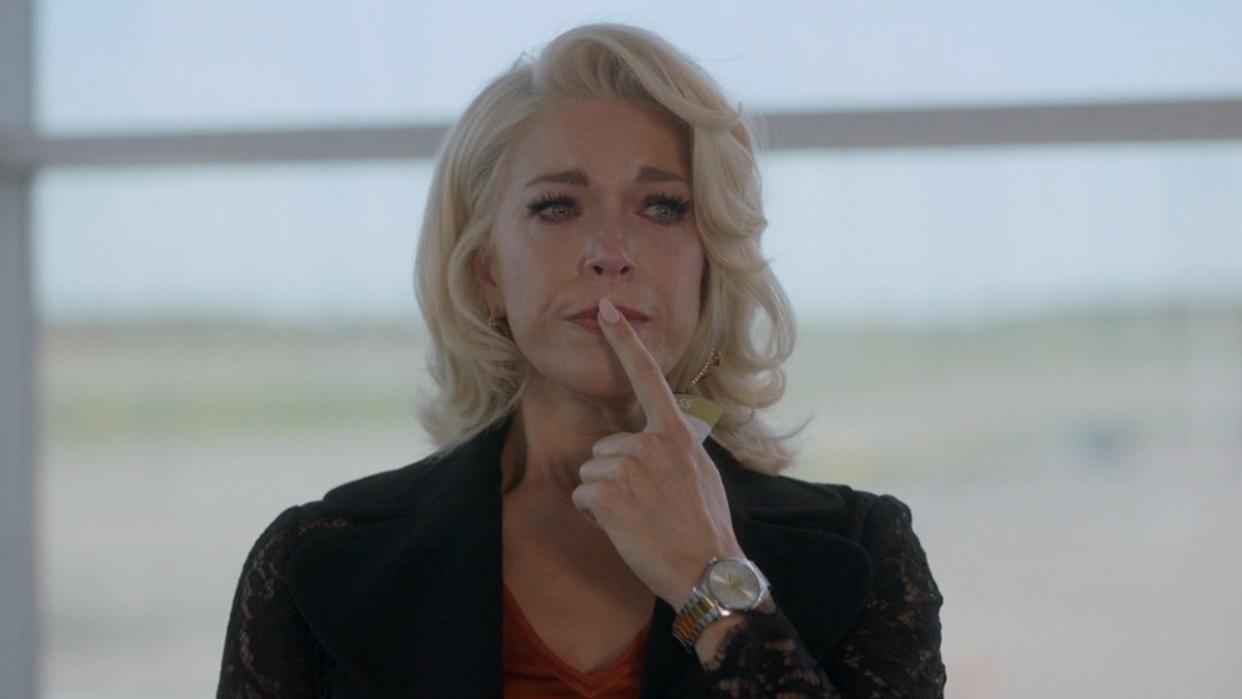  A screenshot of Hannah Waddingham in Ted Lasso's Season 3 finale, in an airport with tears in her eyes, holding her finger up to her lip. 