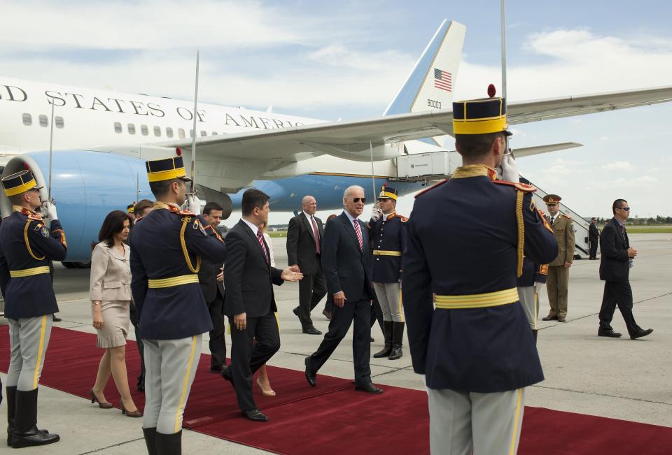 US Vice President Joe Biden (C,R) walks next to Romanian Foreign Minister Titus Corlatean (C,L) after arriving at the 'Henry Coanda' international Airport in Bucharest on May 20, 2014. US Vice President Joe Biden blasted Russia's annexation of Crimea, saying borders should not be changed at gunpoint, as he began a visit to Romania days before a crucial vote in Ukraine.&nbsp;