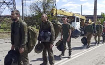 In this photo taken from video released by the Russian Defense Ministry on Friday, May 20, 2022, Ukrainian servicemen are pictured as they leave the besieged Azovstal steel plant in Mariupol, in territory under the government of the Donetsk People's Republic, eastern Ukraine. (Russian Defense Ministry Press Service via AP)