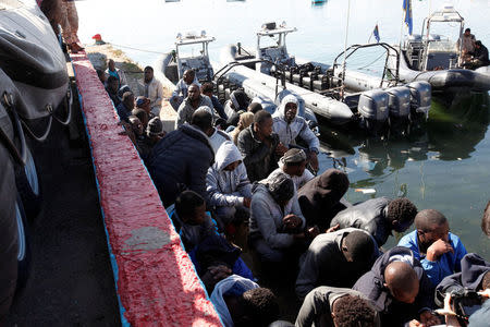 Migrants sit in a port, after being rescued at sea by Libyan coast guard, in Tripoli, Libya April 11, 2016. REUTERS/Ismail Zitouny