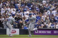 Los Angeles Dodgers' Freddie Freeman, right, celebrates with teammate third base coach Dino Ebel after hitting a home run during the first inning of a baseball game nagainst the San Diego Padres, Saturday, May 11, 2024, in San Diego. (AP Photo/Gregory Bull)