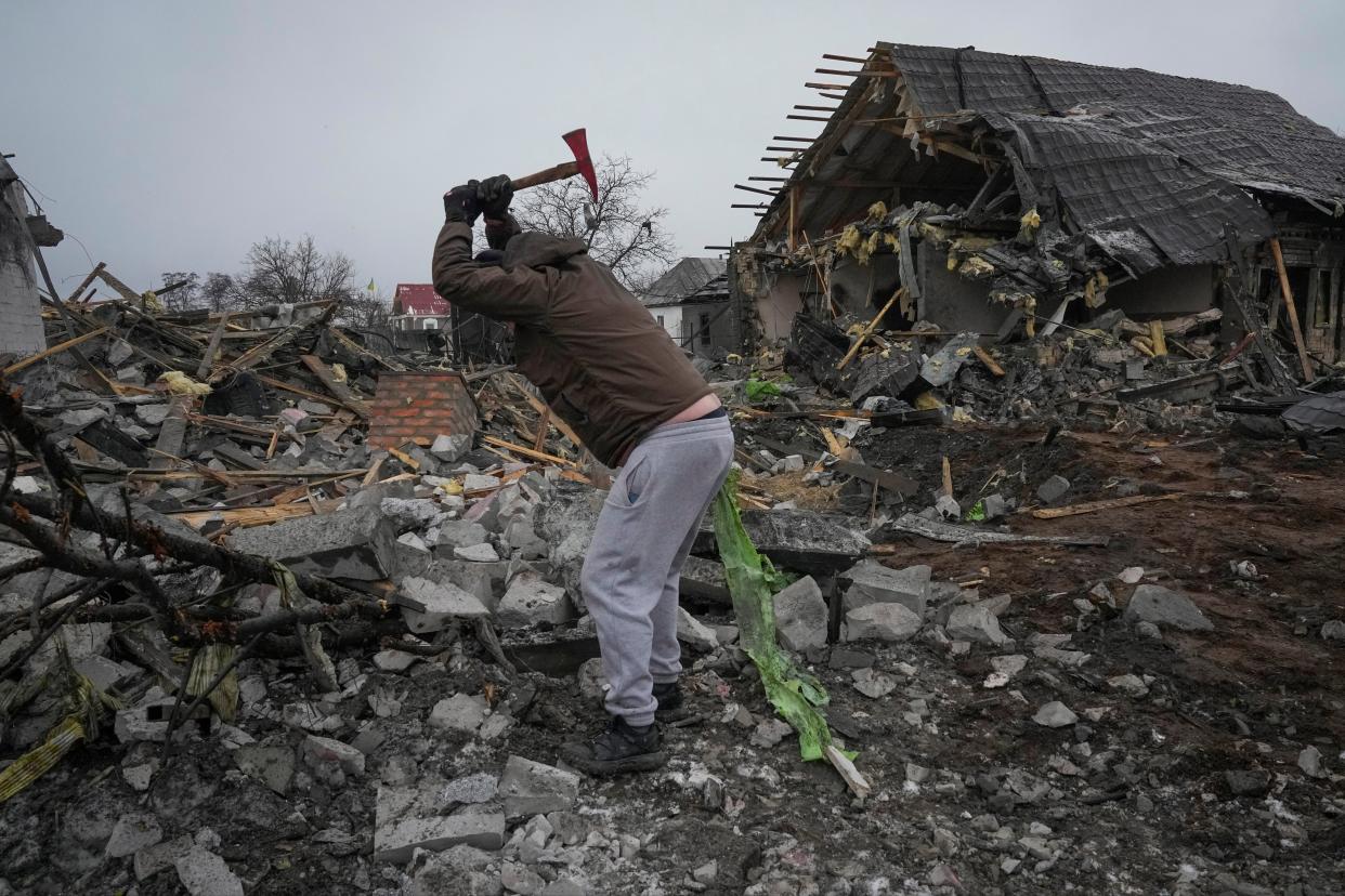 A local resident cleans the debris at a site of a recent Russian missile attack in Kyiv, Ukraine (AP)