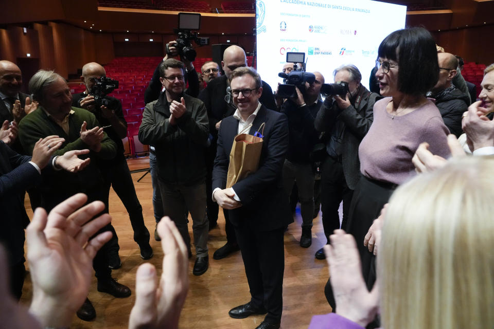 Maestro Daniel Harding, the new music director of Rome's Santa Cecilia orchestra, is cheered by members of his orchestra at the end of a press conference on the occasion of his presentation to media in Rome, Monday, March 6, 2023. British conductor Daniel Harding was named Monday as music director of Rome’s Orchestra dell’Accademia di Santa Cecilia, starting in the fall of 2024. The 47-year-old conductor Harding, who has a second career as an Air France pilot, had an unusually young start as a conductor, and will arrive at the Santa Cecilia orchestra after 17 years as the principal conductor of the Swedish Radio Symphony Orchestra.(AP Photo/Gregorio Borgia)