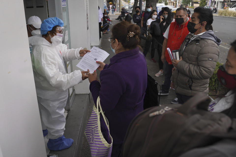 A woman gets her results after getting tested for COVID-19, outside a pharmacy in Mexico City, Monday, Jan. 10, 2022. (AP Photo/Marco Ugarte)