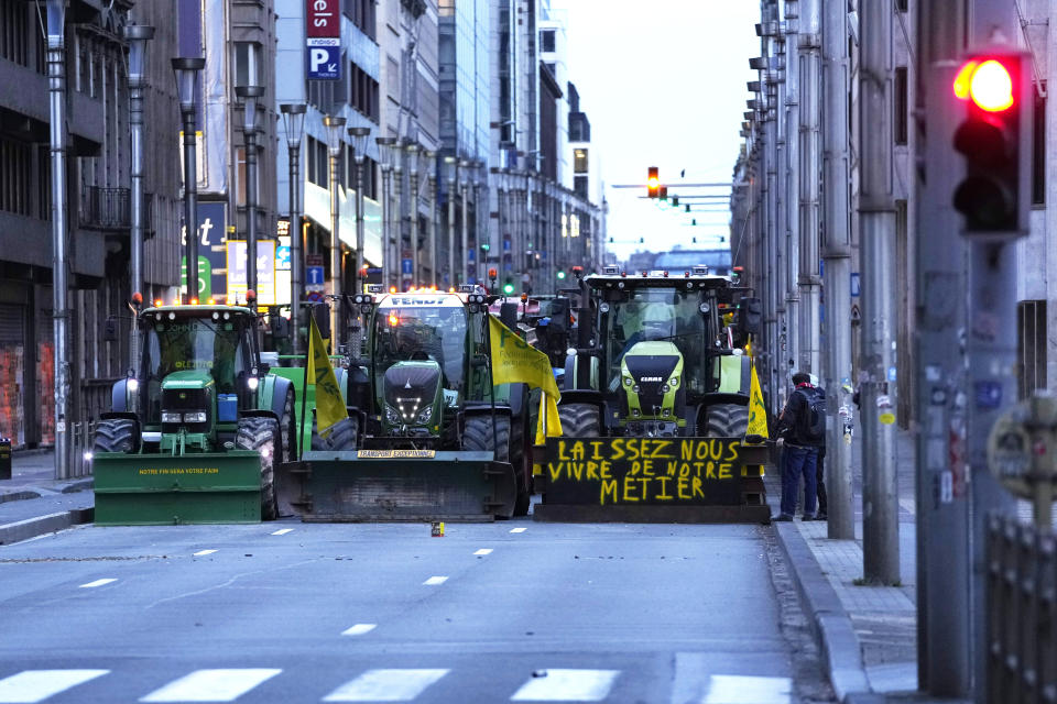 Farmers with their tractors begin to arrive, near the European Quarter in Brussels, during a demonstration outside of a meeting of EU agriculture ministers at the European Council building in Brussels, Tuesday, March 26, 2024. Tuesday marks the third time this year that farmers will take to the streets of Brussels with their tractors. Sign on tractor reads "Let us live from our profession." (AP Photo/Virginia Mayo)