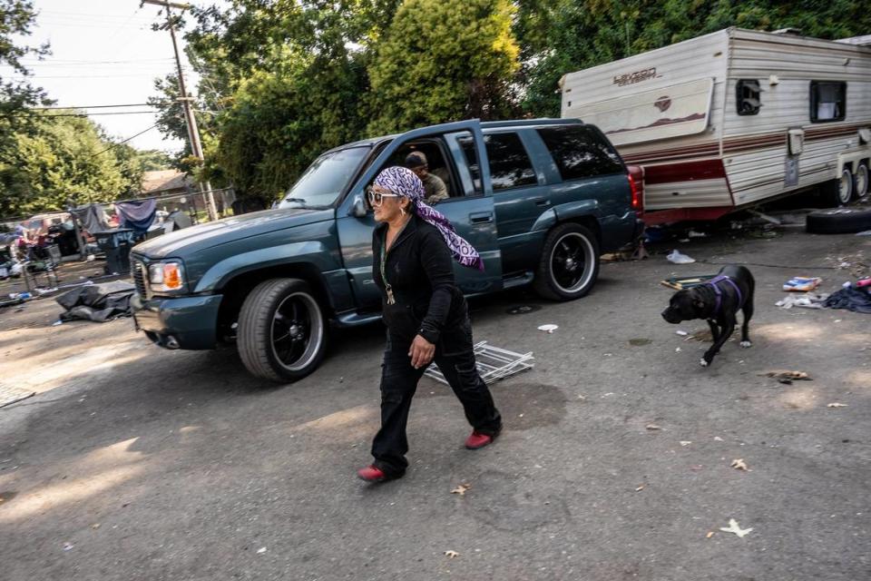As a friend tries to tow her trailer, Gracie Parsley and her dog Diamond race to make sure her inoperable car isn’t being towed amid a homeless encampment sweep on 1st Avenue by the city of Sacramento on Wednesday.