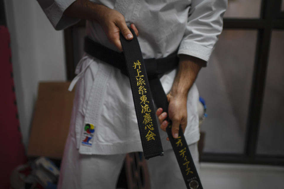 El karateka venezolano Antonio Díaz, bicampeón mundial, se amarra la cinta negra antes de entrenar en su dojo en Caracas, el viernes 24 de abril de 2020 (AP Foto/Matías Delacroix)