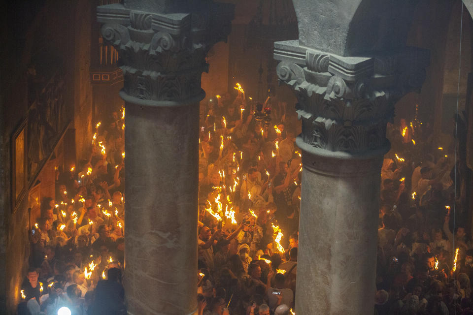 Christian pilgrims hold candles as they gather during the ceremony of the Holy Fire at Church of the Holy Sepulchre, where many Christians believe Jesus was crucified, buried and rose from the dead, in the Old City of Jerusalem, Saturday, May 1, 2021. Hundreds of Christian worshippers took use of Israel's easing of coronavirus restrictions Saturday and packed a Jerusalem church revered as the site of Jesus' crucifixion and resurrection for an ancient fire ceremony ahead of Orthodox Easter. (AP Photo/Ariel Schalit)