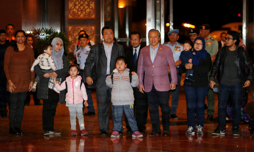 Malaysia's Foreign Minister Anifah Anan (3rd R) walks with the nine Malaysian citizens who were previously stranded in Pyongyang as they return home, at the Kuala Lumpur International Airport in Sepang, Malaysia March 31, 2017. REUTERS/Lai Seng Sin