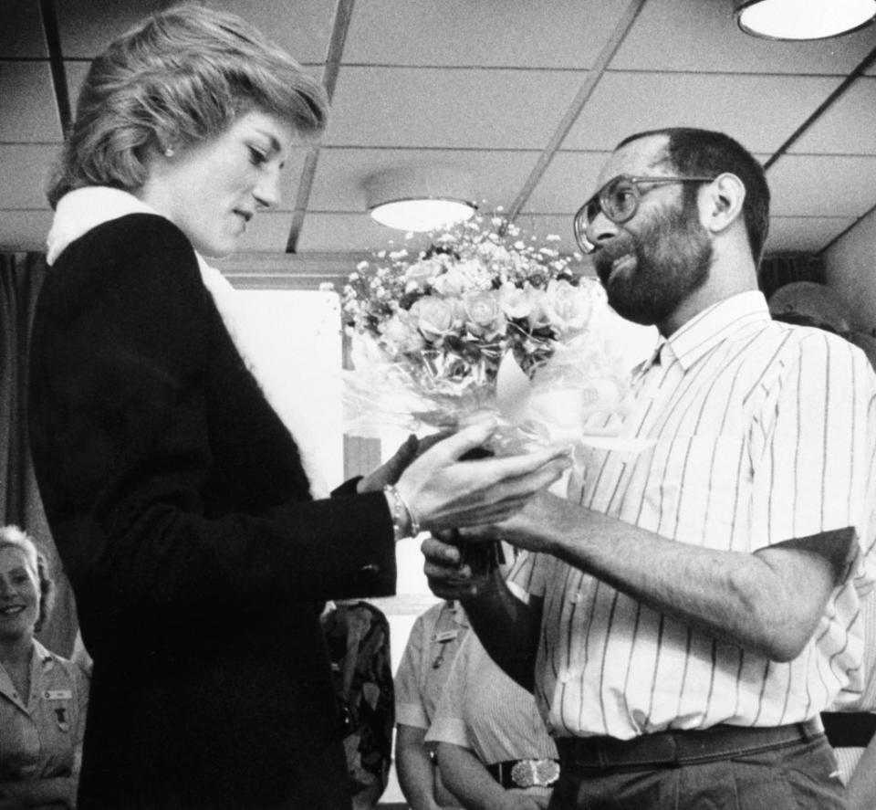 Diana is presented with a bouquet by Aids patient Martin Johnson during her visit to the Mildmay Mission Hospital Aids Hospice in East London in February 1989 (PA) (PA Archive)