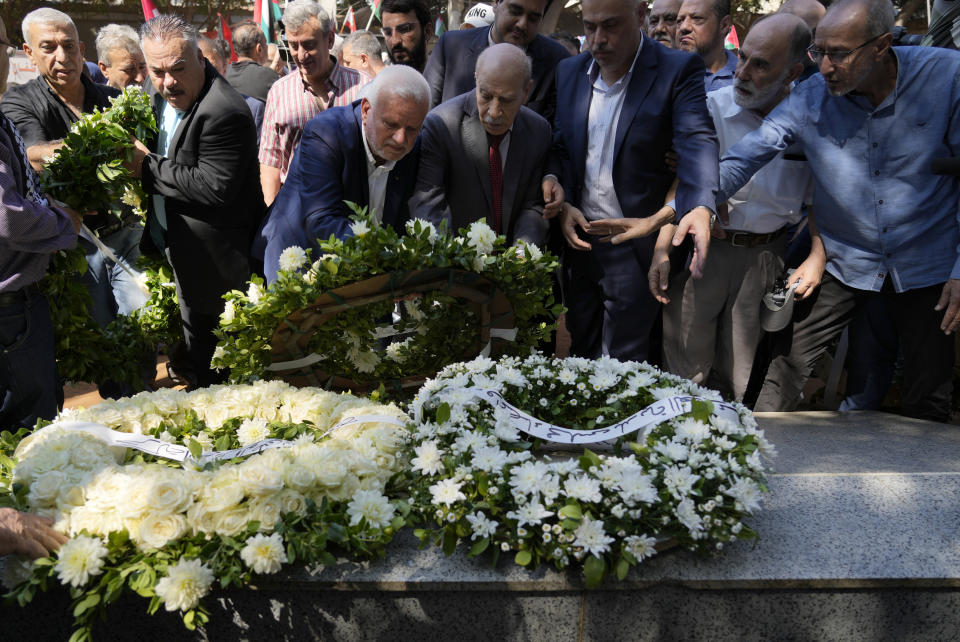 Palestinian ambassador to Lebanon Ashraf Dabbour, center left, lays a wreath on a memorial monument with other Lebanese and Palestinian officials, as they commemorate the 40th anniversary of the Sabra and Shatila massacre, at the mass grave where the massacre's victims buried, in Beirut, Lebanon, Friday, Sept. 16, 2022. During the Israeli's invasion of Lebanon in 1982, Palestinian men, women and children were massacred by forces identified as Lebanese Christian militiamen in west Beirut's Sabra and Shatila refugee camps. The official toll is 328 confirmed killed, 991 missing. (AP Photo/Bilal Hussein)