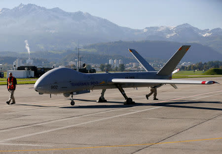 FILE PHOTO: Ground crew walks next to the Israeli Elbit Systems Ltd. Hermes 900 unmanned aerial vehicle (UAV) during a presentation at the airbase in the central Swiss town of Emmen October 16, 2012. REUTERS/Pascal Lauener/File Photo