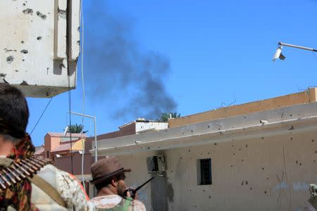 Fighters from Libyan forces allied with the U.N.-backed government take position as smoke rises during a battle with Islamic State militants in Sirte, Libya September 22, 2016. REUTERS/Ismail Zitouny