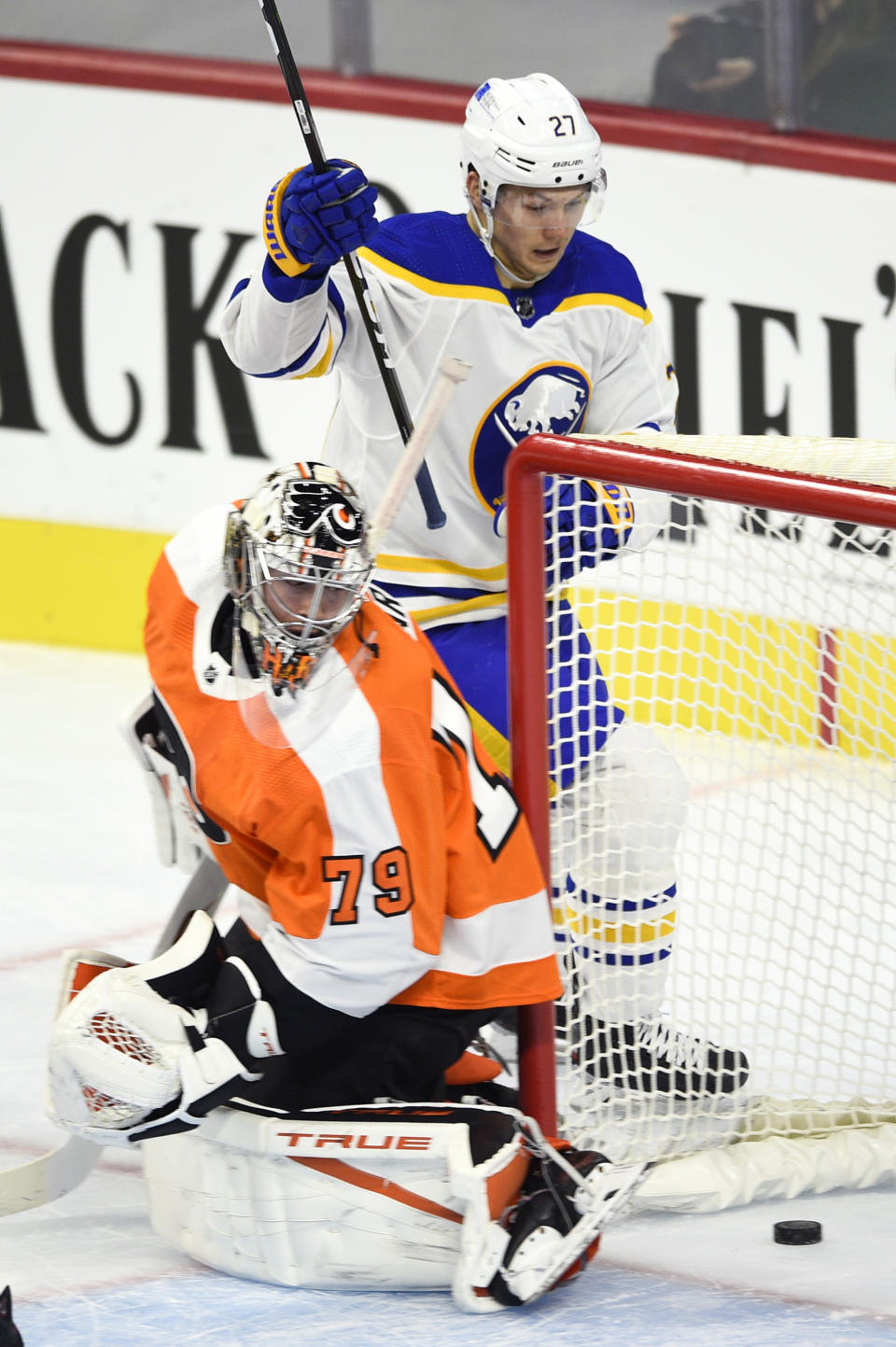 Buffalo Sabres' Curtis Lazar, rear, looks at the puck after scoring a goal past Philadelphia Flyers goaltender Carter Hart during the first period of an NHL hockey game, Monday, Jan. 18, 2021, in Philadelphia. (AP Photo/Derik Hamilton)