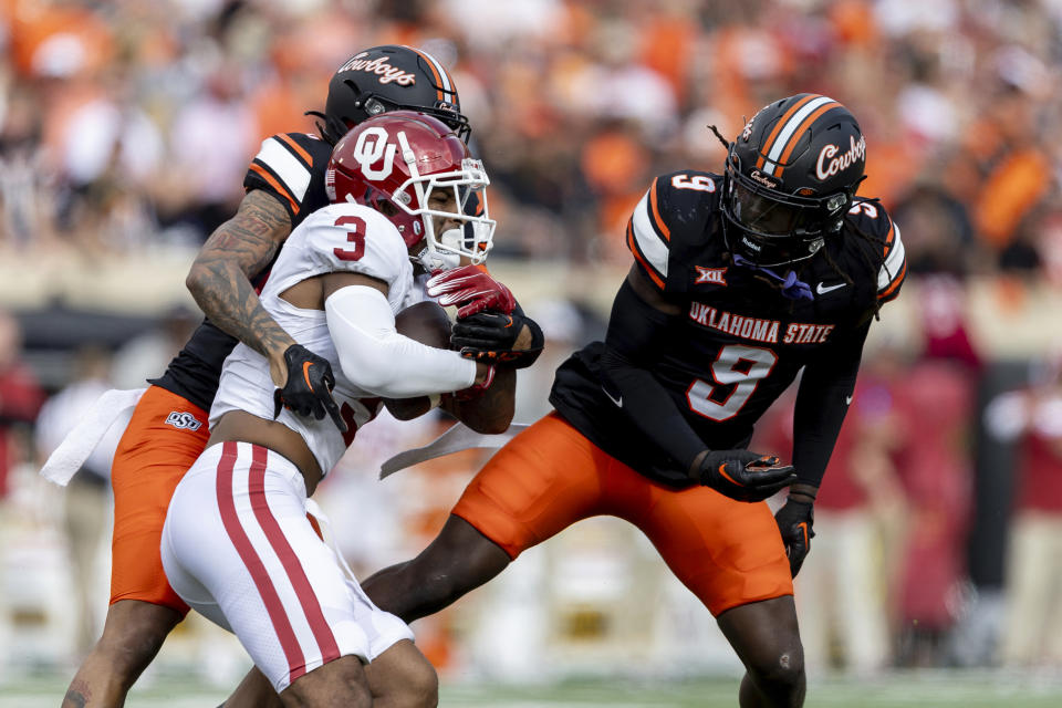 Oklahoma State cornerback Korie Black, left, and safety Trey Rucker, right, tackle Oklahoma wide receiver Jalil Farooq (3) in the first half of an NCAA college football game Saturday, Nov. 4, 2023, in Stillwater, Okla. (AP Photo/Mitch Alcala)