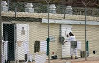 GUANTANAMO BAY, CUBA - OCTOBER 2: (IMAGE REVIEWED BY U.S. MILITARY PRIOR TO TRANSMISSION) A detainee moves from one room to another inside Camp 1 at the detention facility at the U.S. Naval Station October 2, 2007 in Guantanamo Bay, Cuba. About 340 "unlawful enemy combatants" captured since the September 11, 2001 attacks on the United States continue to be held at the facility. (Photo by Chip Somodevilla/Getty Images)