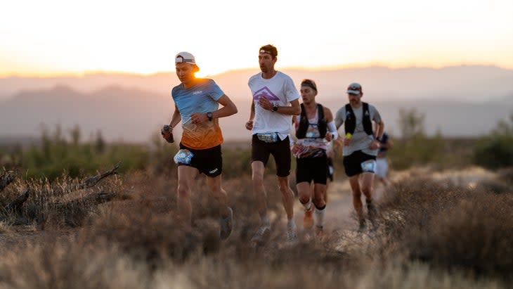 elite men running a trail in the desert at sunup