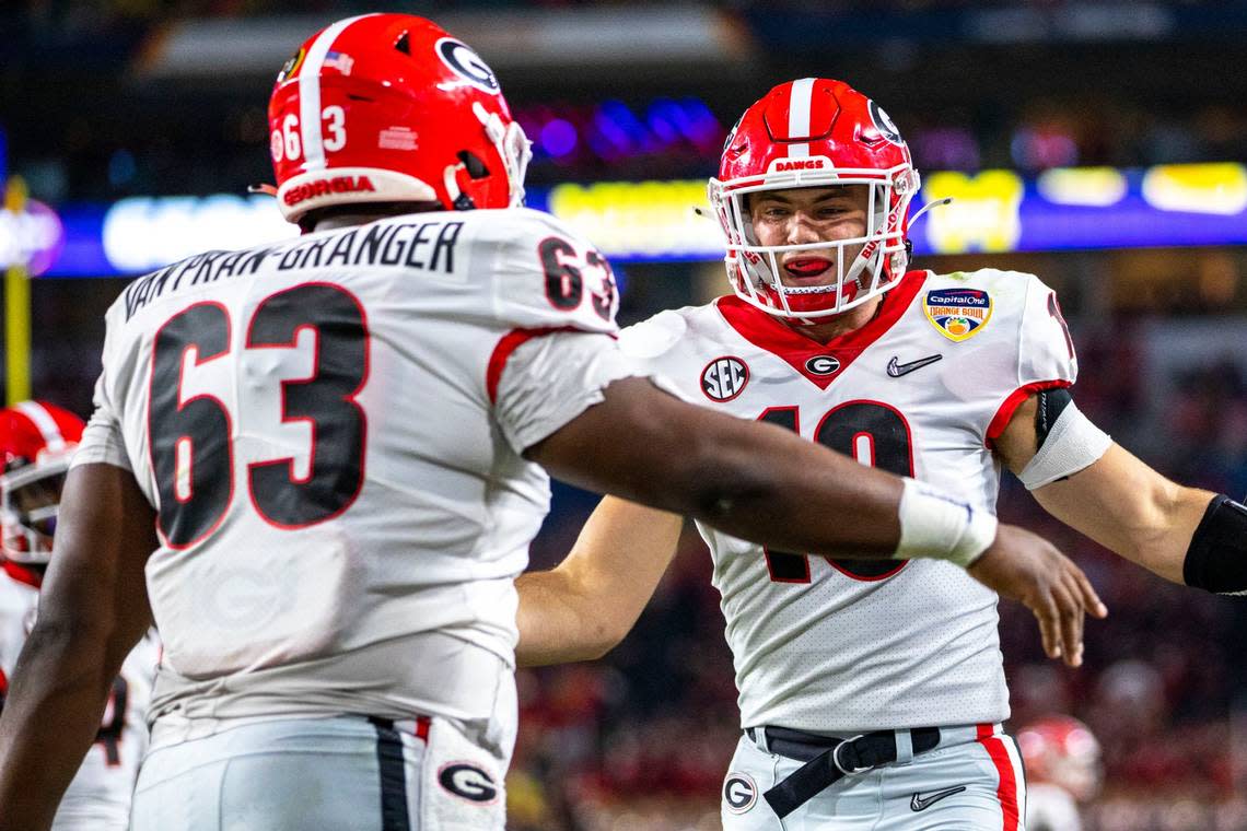 University of Georgia tight end Brock Bowers (19) celebrates with teammate offensive lineman Sedrick Van Pran- Granger (63) after scoring a touchdown against University of Michigan during the first quarter of the 2021 College Football Playoff Semifinal at the Capital One Orange Bowl hosted at Hard Rock Stadium in Miami Gardens, Florida, on Friday, December 31, 2021. Daniel A. Varela/dvarela@miamiherald.com