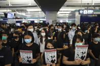 Demonstrators stand during a protest at the Yuen Long MTR station, where demonstrators and others were violently attacked by men in white T-shirts following an earlier protest in July, in Hong Kong, Wednesday, Aug. 21, 2019. Hundreds of Hong Kong protesters held a sit-in at a suburban train station to mark the anniversary of a violent attack there by masked assailants on supporters of the antigovernment movement. (AP Photo/Kin Cheung)