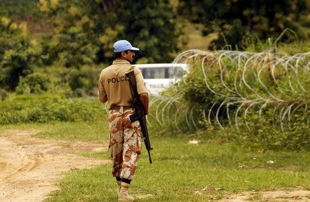 A UN peacekeeping force soldier patrols as he guards an area where severals wells containing the remains of massacred civilians were found, in Duekoue, west Ivory Coast, June 23, 2015. Picture taken June 23, 2015. REUTERS/Luc Gnago